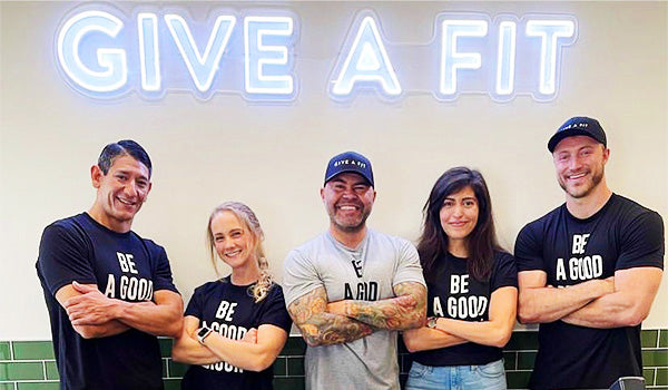 MyFitFoods Team photo with 'Give A Fit' neon