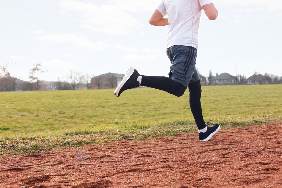 image of a person running on a path through a field 