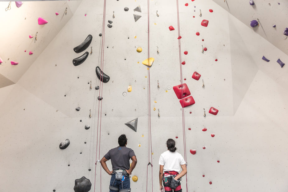 image of 2 climbers staring at a wall in a climbing gym